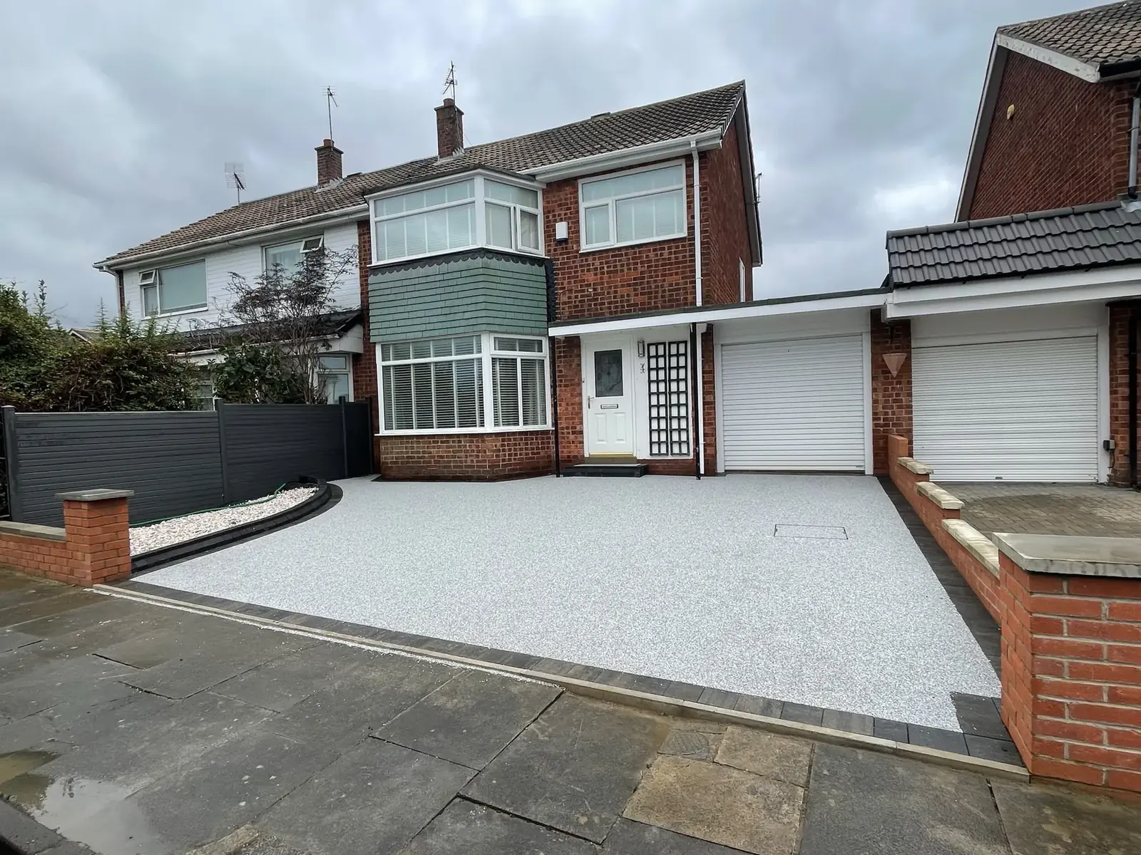 Completed silver grey resin driveway in front of a rendered house in the North East