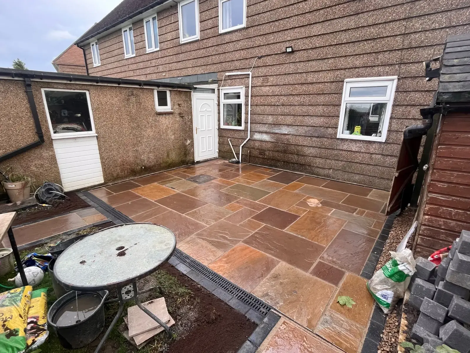 Completed natural sandstone patio in mixed warm tones in a North East back garden