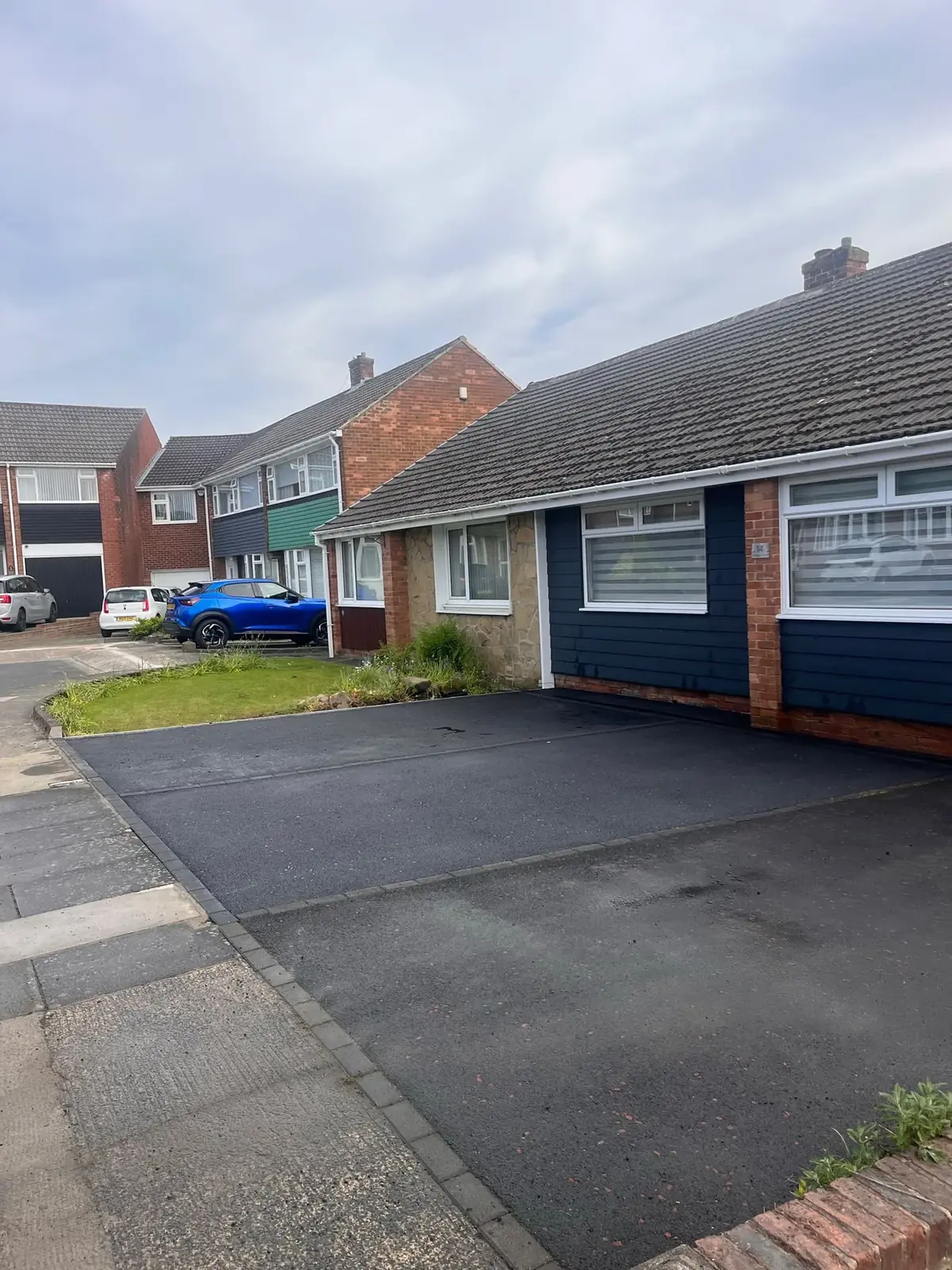 Completed dark driveway with pale block edging at a brick bungalow in the North East