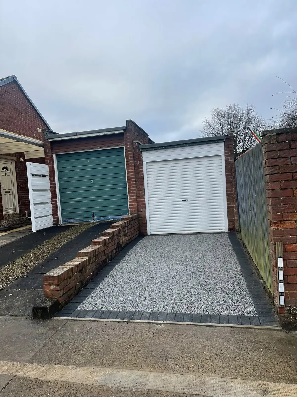 Completed grey resin bound single driveway leading to a garage at a North East home