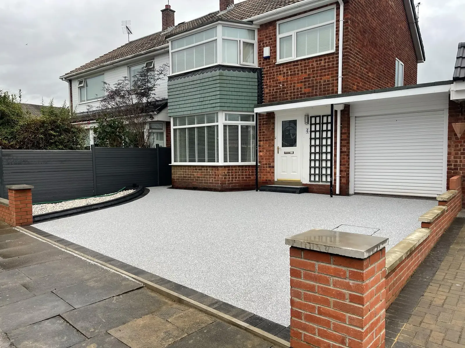 Completed light grey resin bound driveway at a brick semi-detached house in Newcastle
